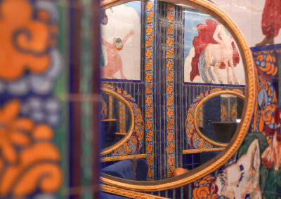 Détail d'une fresque en céramique reflétée dans un miroir doré