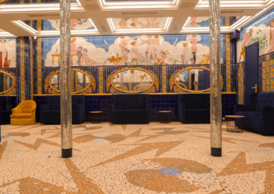 Le grand salon Aux Belles Poules : céramiques d'époque, miroirs ovales dorés et sol en mosaïque