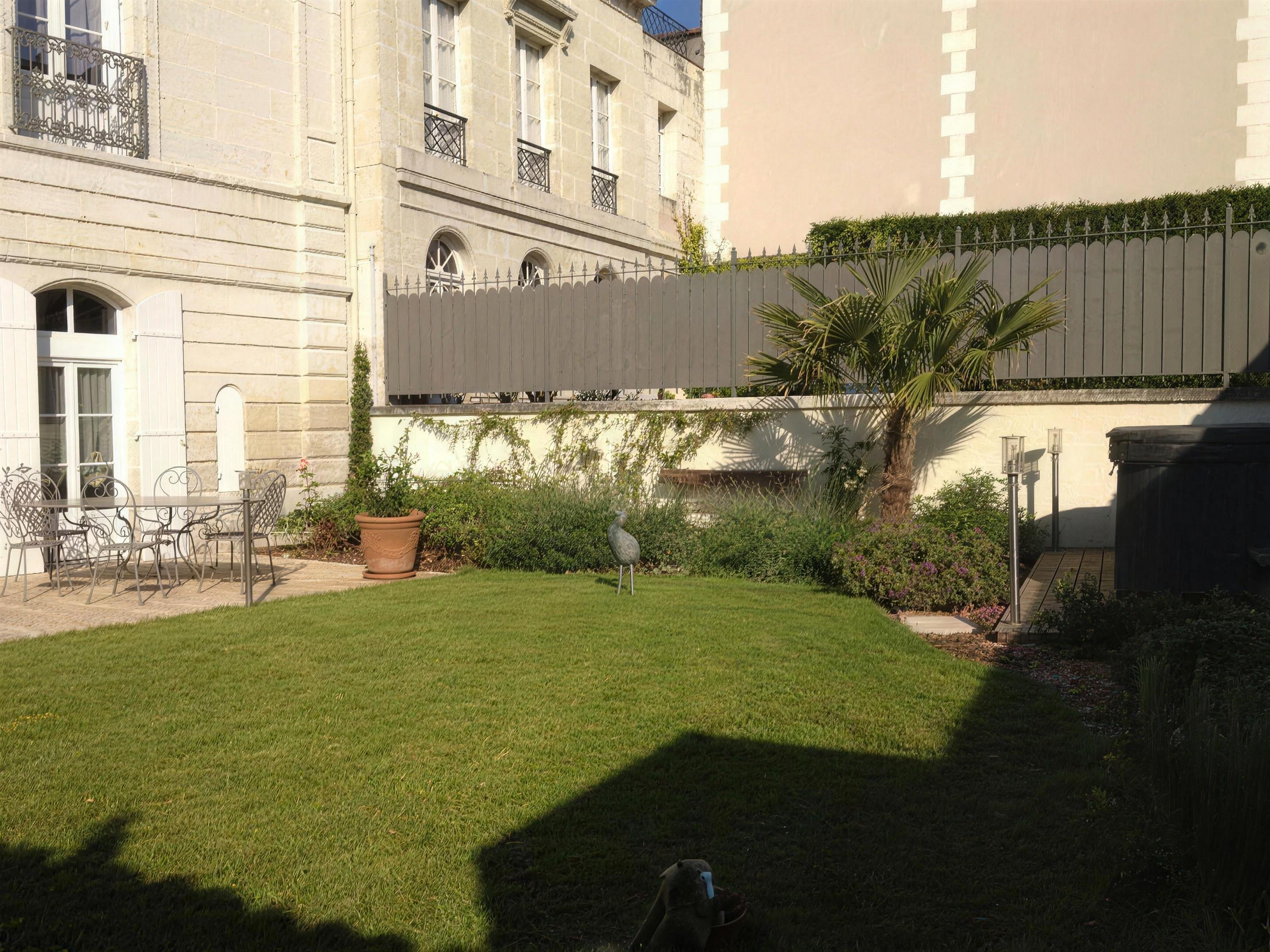 Jardin de ville avec pelouse et immeuble haussmannien