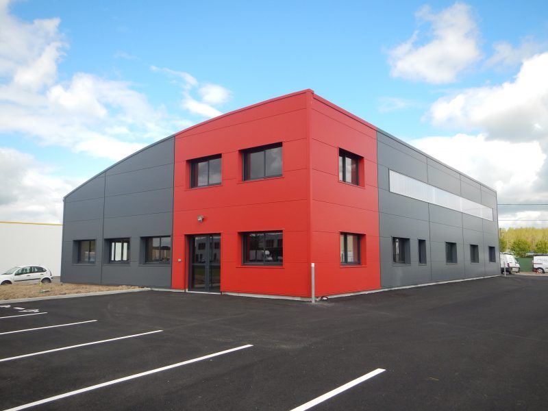Bâtiment industriel construit par Moreau, bardage gris et rouge