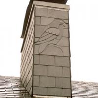 Oiseau sculpté dans l'ardoise sur une souche de cheminée