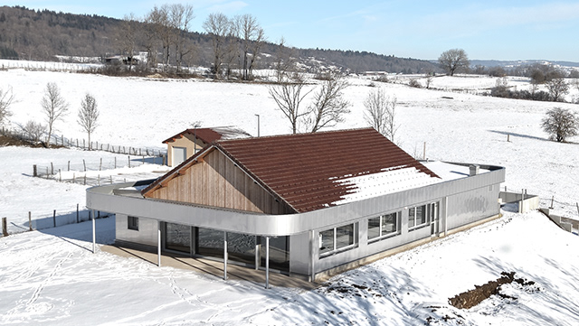 Maison contemporaine a toiture bois et zinc, sous la neige a Dommartin