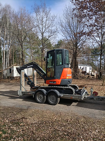 Mini-pelle transportée sur remorque vers un chantier