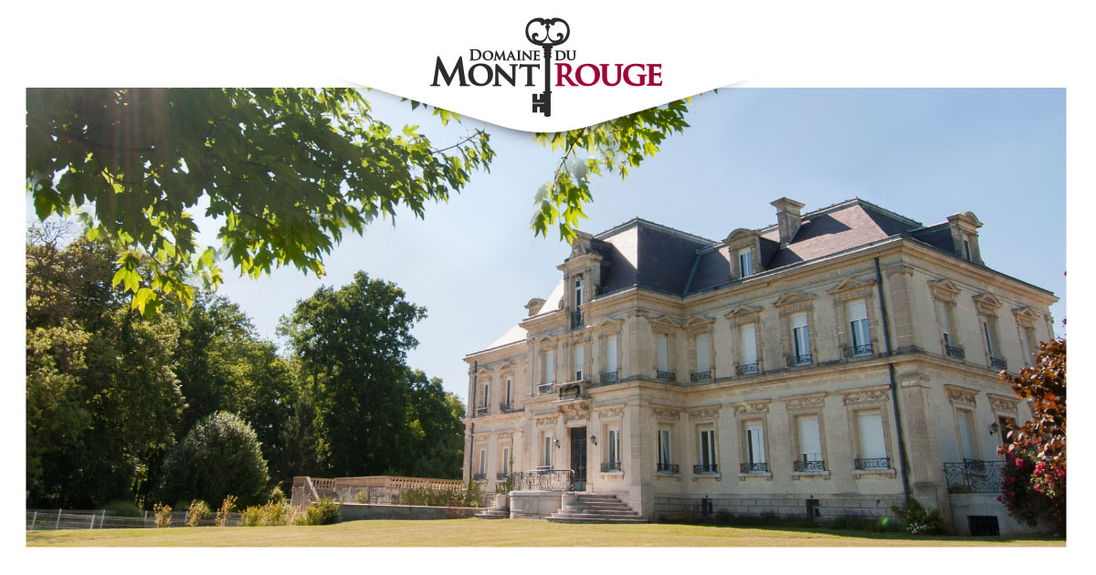 Façade du château du Domaine du Mont Rouge sous le soleil, bordée d'arbres