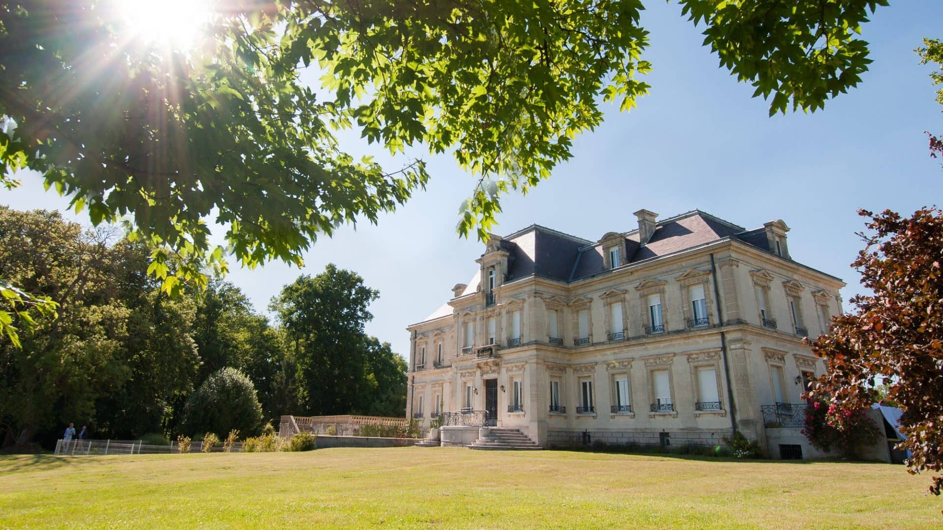 Le château du Domaine du Mont Rouge au soleil, vu depuis le parc en pelouse