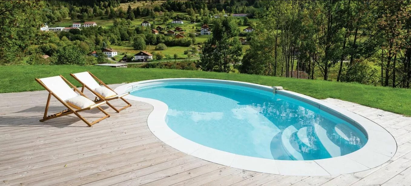Piscine forme haricot surplombant un village du Gers dans la vallée