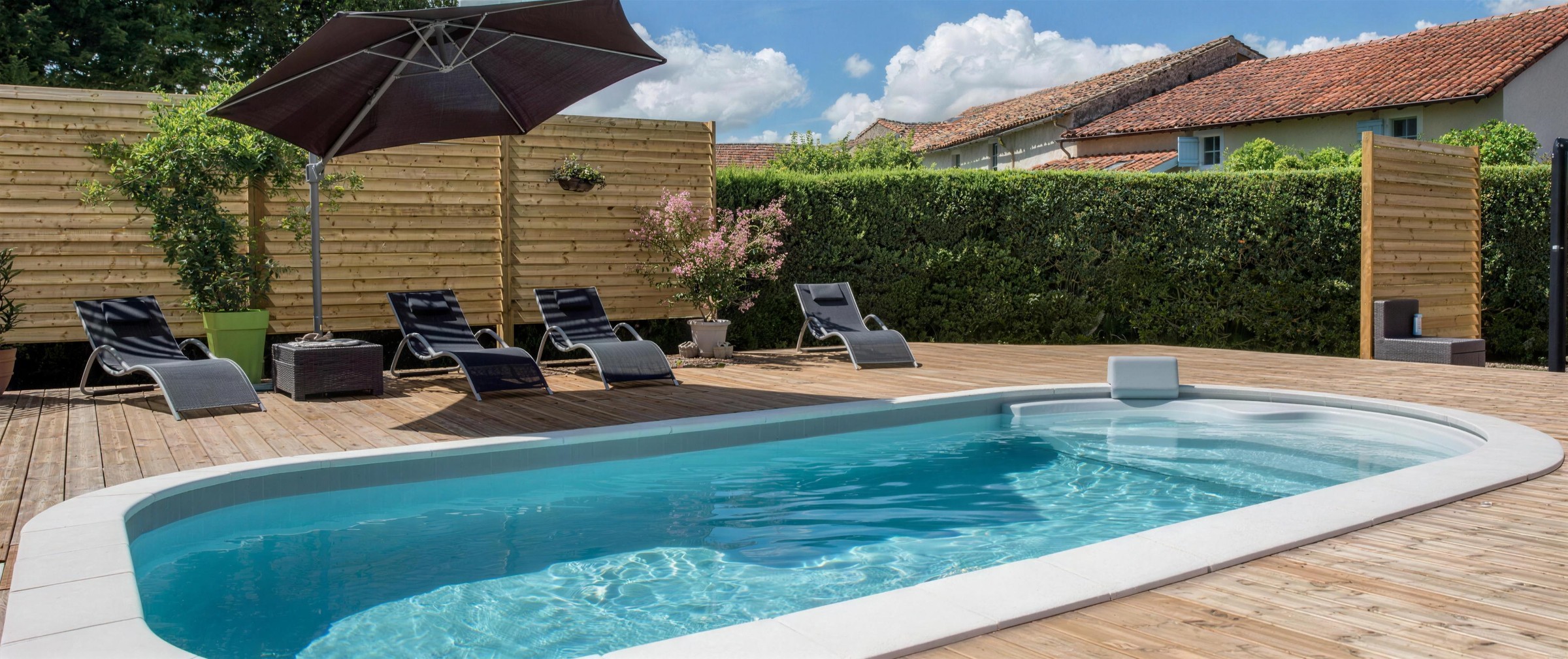 Piscine EAUSOL avec terrasse bois, parasol et transats dans le Gers
