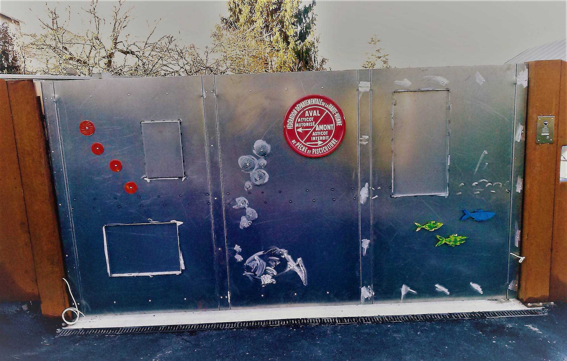 Grand panneau de portail en métal gravé d'une scène aquatique avec poissons et médaillon rouge