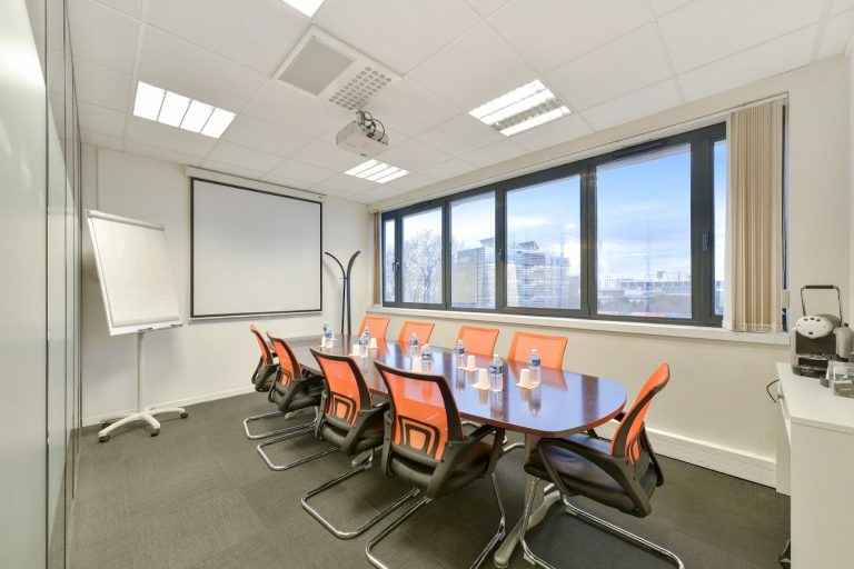 Salle de réunion lumineuse avec écran et paperboard
