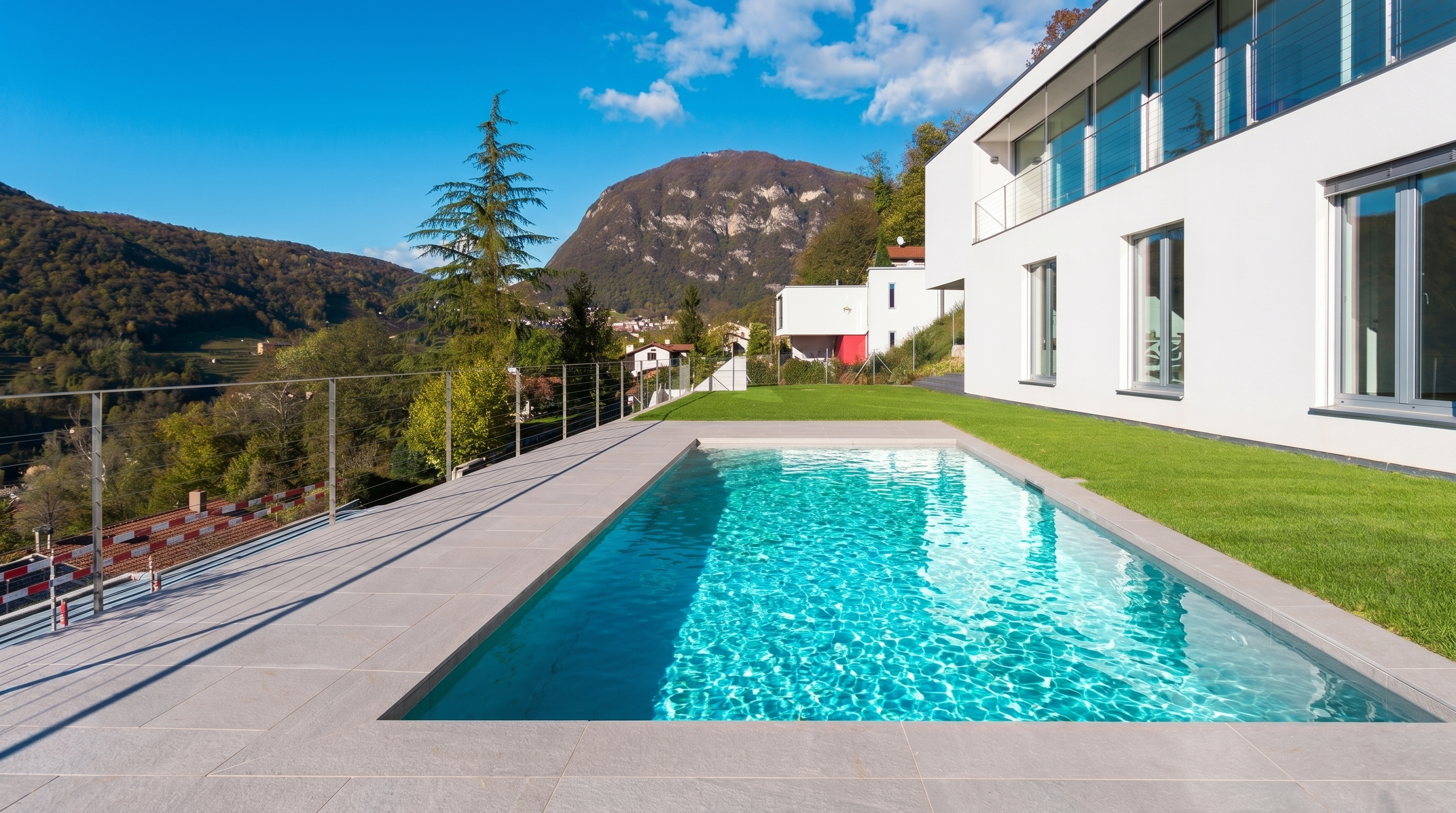 Piscine béton achevée avec villa et vue sur la montagne