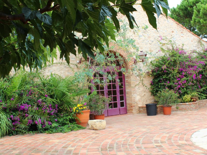 Patio catalan, porte ancienne et bougainvilliers en fleurs