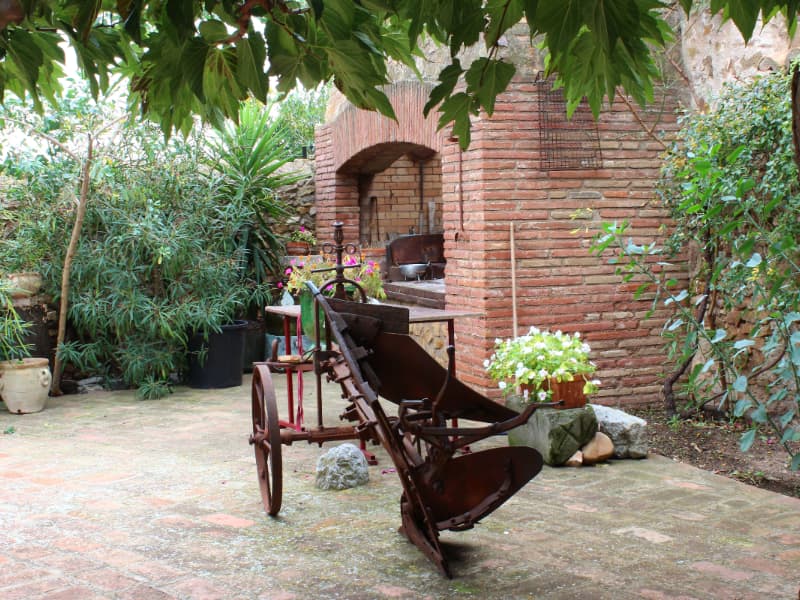 Détail du patio, four en briques et charrue ancienne
