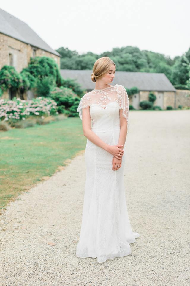 Mariee devant le corps de ferme et les jardins fleuris du domaine