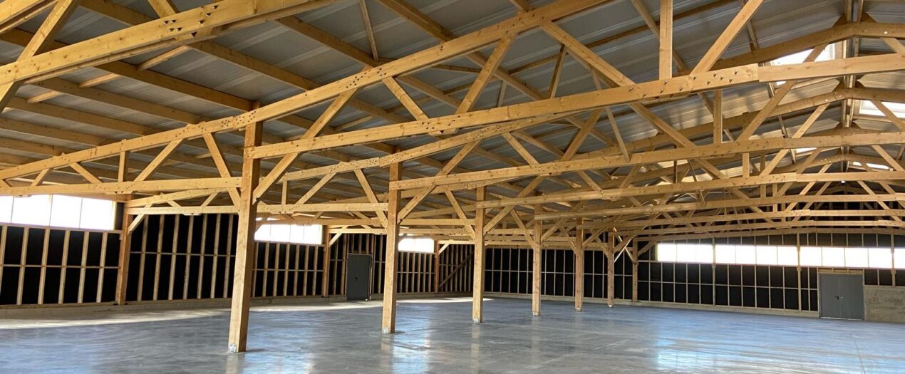 Charpente bois d'un grand bâtiment Le Bâtiment Bois, structure et fermes apparentes baignées de lumière