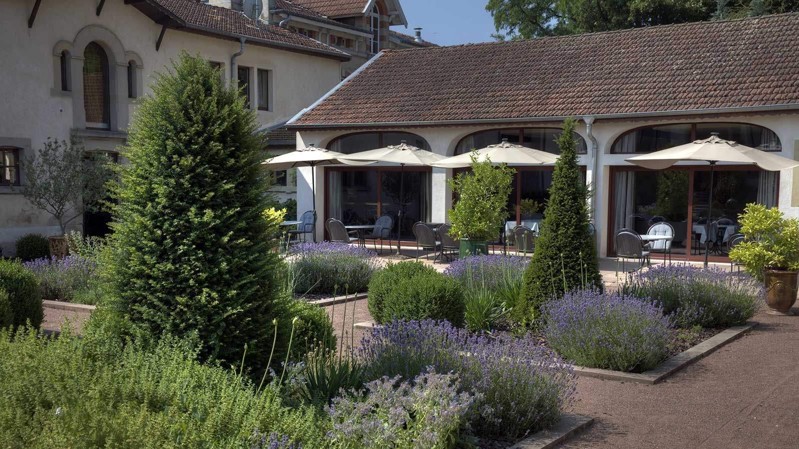 La terrasse dressée au cœur du jardin de lavande, sous la lumière de fin de journée.