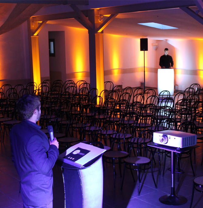 La salle de reception dressee et mise en lumiere pour une soiree.