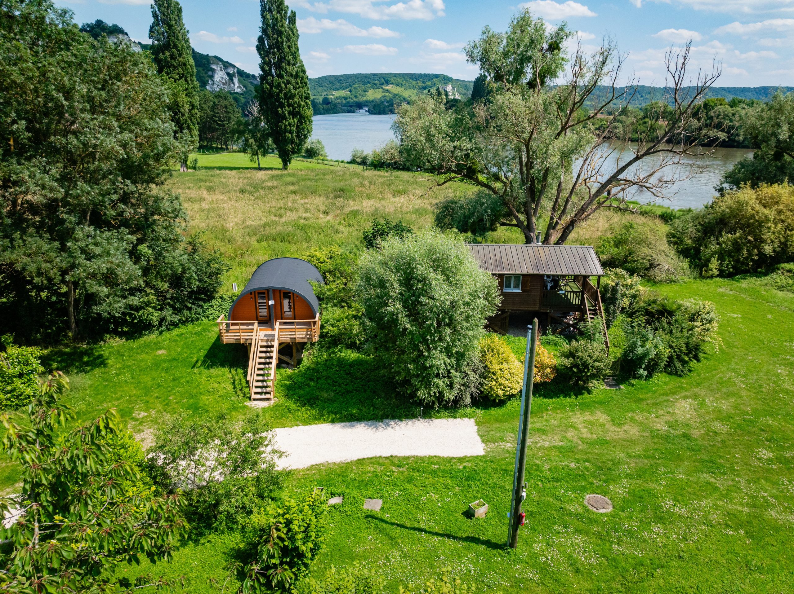 Vue aérienne du domaine au bord de la Seine, parc verdoyant et falaises blanches en arrière-plan, aux Andelys
