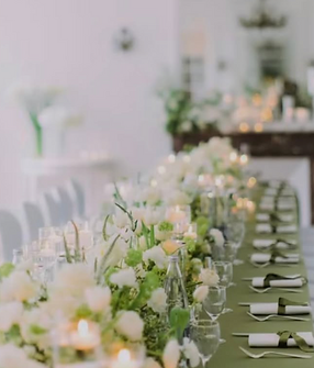 Table d'honneur fleurie, bougies et chemin de roses blanches.