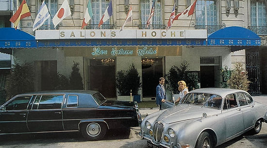 Les Salons Hoche dans les années d'après-guerre, marquise, drapeaux et voitures de collection devant l'entrée.