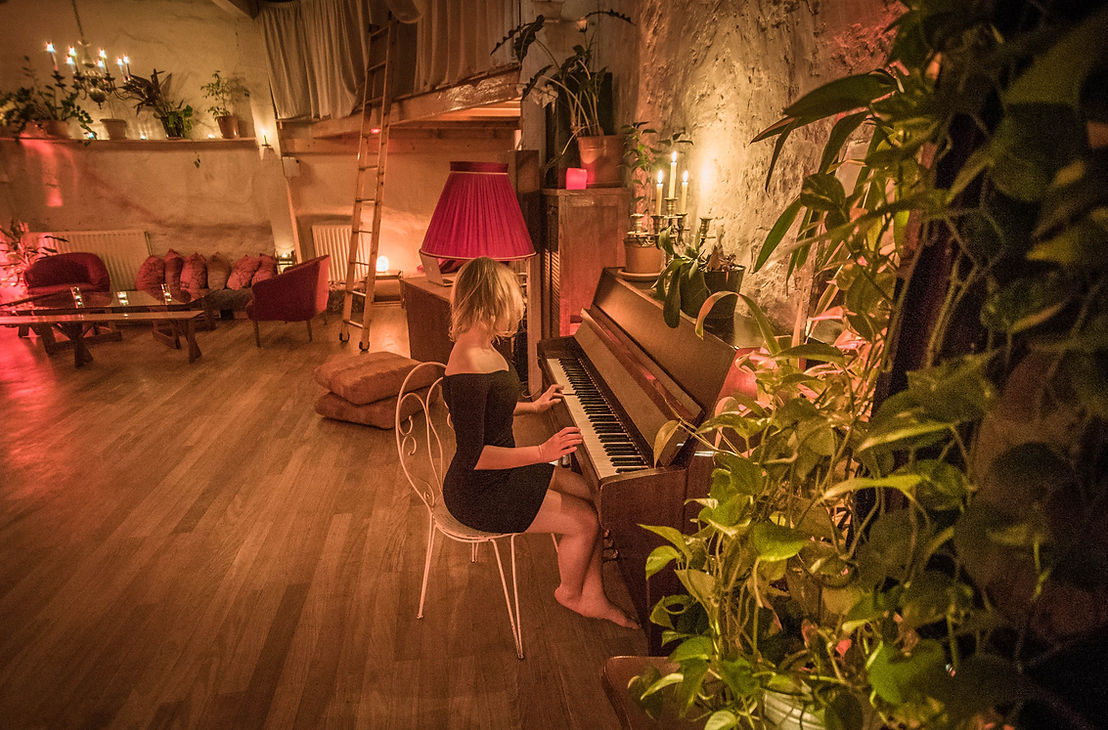 Piano et lampe rose dans la p&eacute;nombre chaude du loft