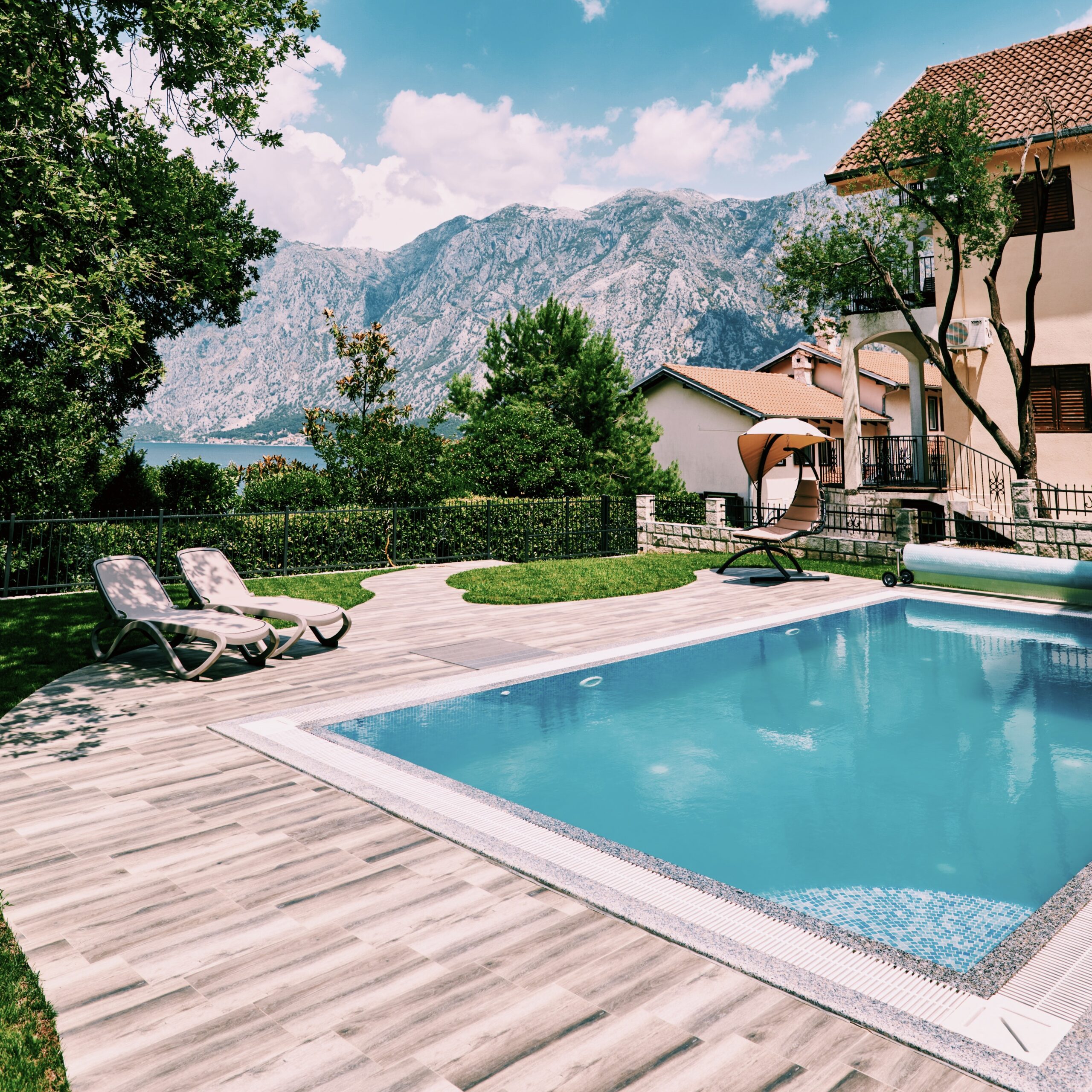 Piscine coque polyester finie avec terrasse, transats et vue sur les hauteurs