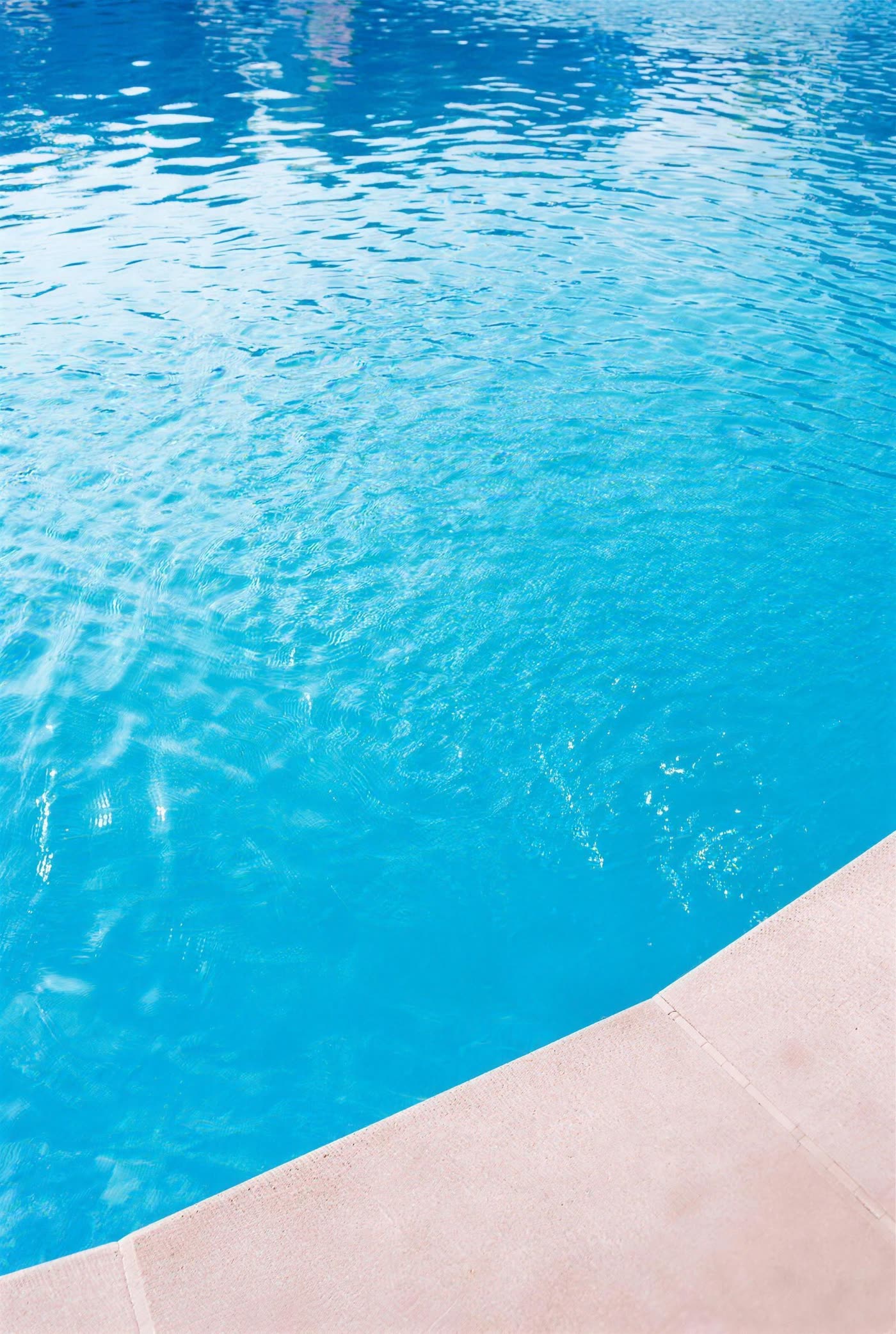 Surface lisse et turquoise de l'eau d'une piscine coque polyester
