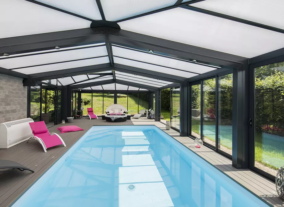 Véranda piscine Soko avec toiture vitrée et grandes baies, abritant une piscine intérieure